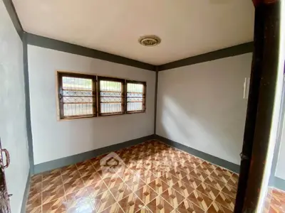 Spacious empty room with tiled floor and large windows, perfect for customization.