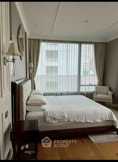 Luxurious bedroom with elegant decor and large windows offering city views.