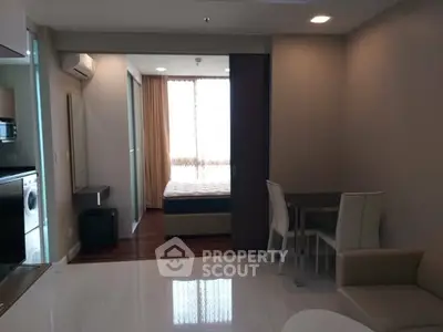 Modern apartment interior with open layout, featuring a cozy living area and adjacent bedroom.