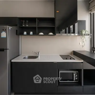 Modern kitchen with sleek black cabinetry and built-in appliances, featuring a compact design and large window.