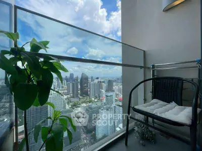 Stunning cityscape view from a modern high-rise balcony with seating area.