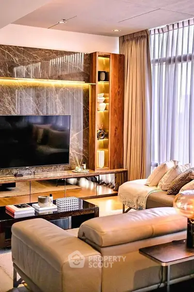 Luxurious living room with modern decor, large TV, and elegant lighting.