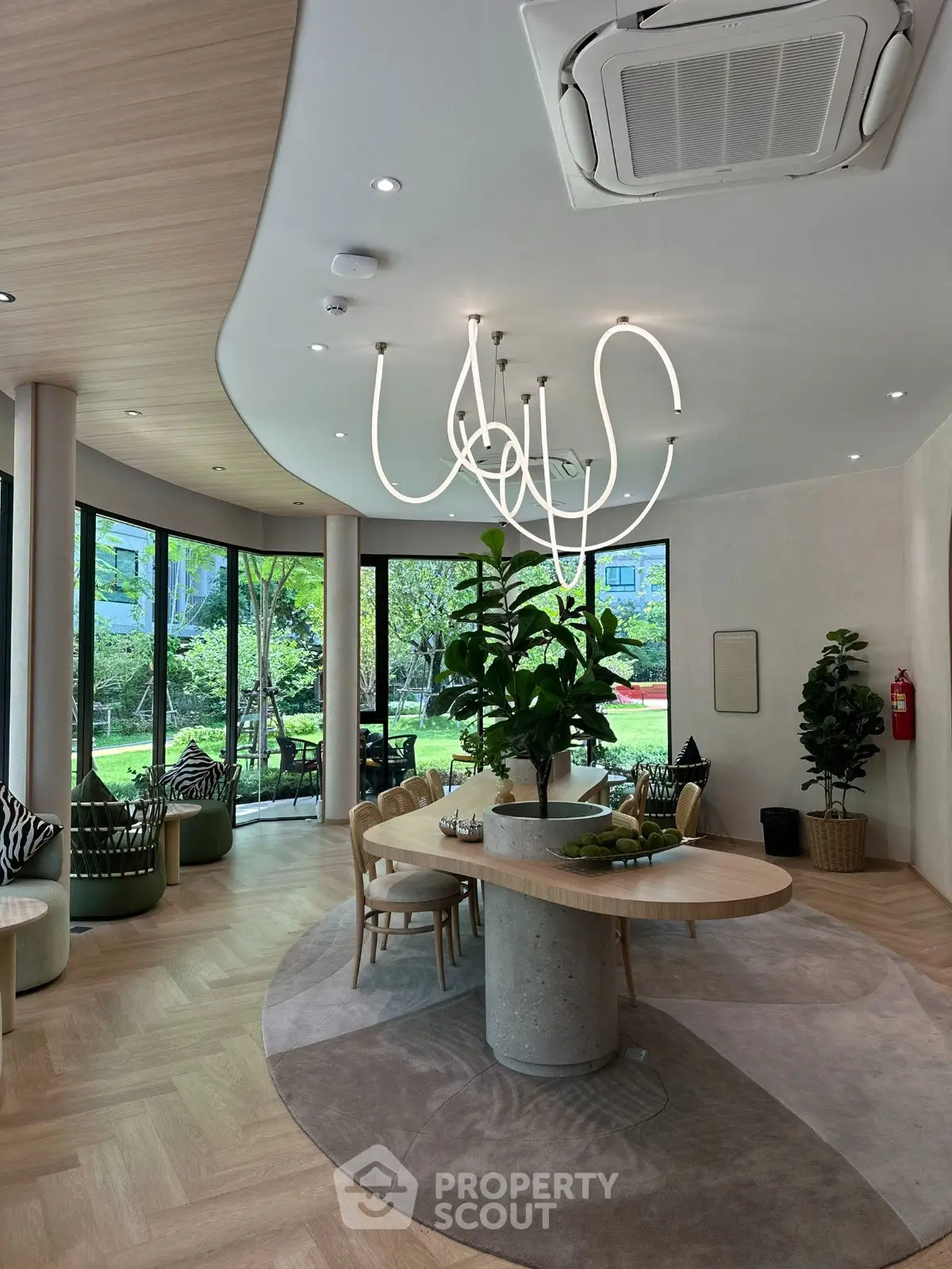Modern living room with stylish lighting, large windows, and lush garden view.