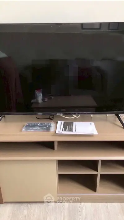 Modern living room with sleek TV setup and stylish wooden console.