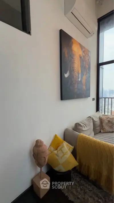 Stylish living room with modern decor and city view, featuring cozy sofa and elephant artwork.