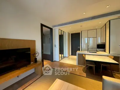 Modern open-plan living room and kitchen with sleek design and natural lighting.