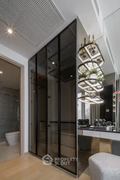 Luxurious modern bathroom with sleek glass closet and elegant lighting fixtures.