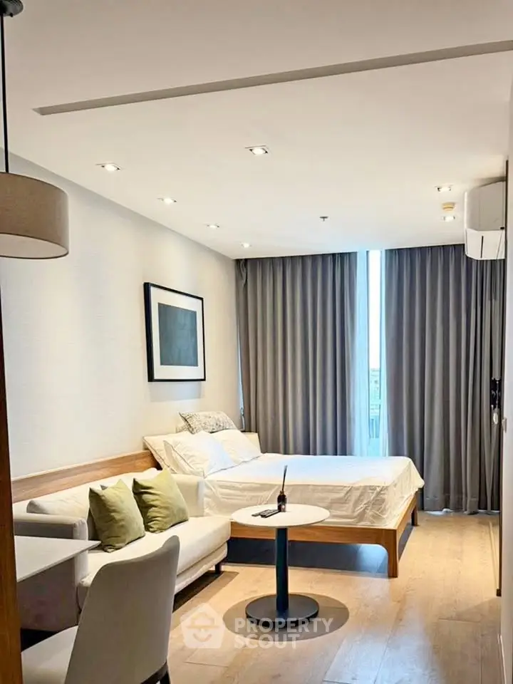 Modern bedroom with cozy seating area and natural light
