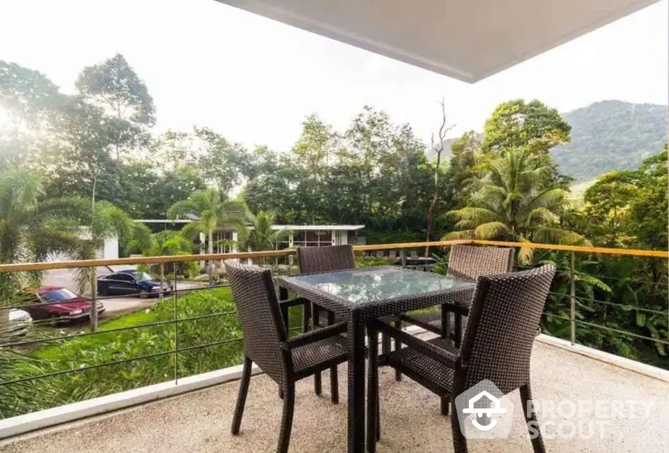 Spacious balcony with outdoor dining set and lush green view