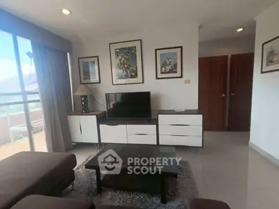 Stylish living room with modern furniture and large window offering natural light and scenic views.