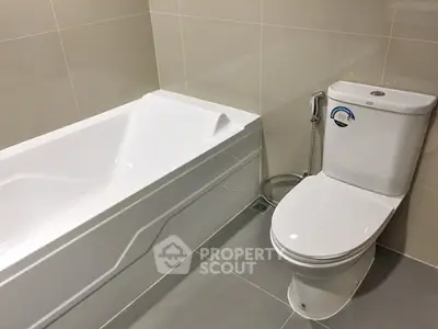 Modern bathroom with sleek bathtub and toilet in a contemporary real estate property.
