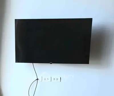 Modern wall-mounted TV in a sleek living room setting, perfect for entertainment.