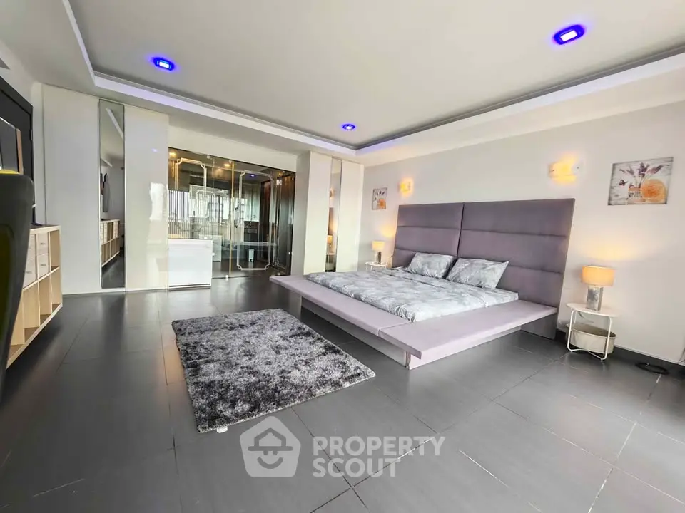 Luxurious modern bedroom with sleek design and spacious layout, featuring elegant lighting and contemporary decor.