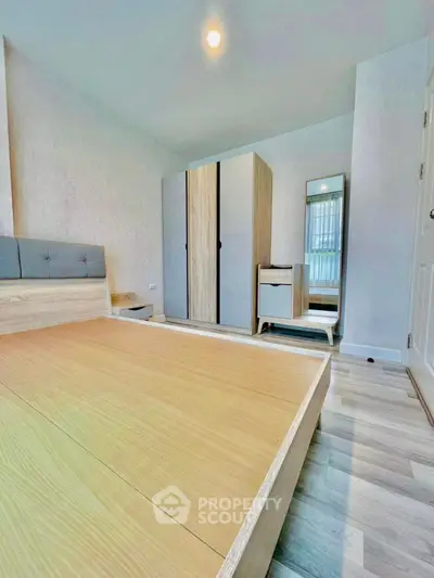 Modern bedroom with minimalist design, featuring wooden flooring and stylish furniture.
