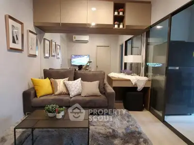 Modern living room with cozy sofa, stylish decor, and sleek glass partition in a contemporary apartment.