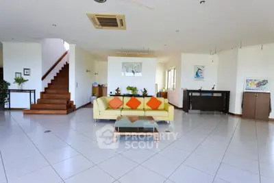 Spacious living room with modern decor and staircase in a bright open layout.