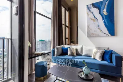 Modern living room with blue sofa and large windows offering city views