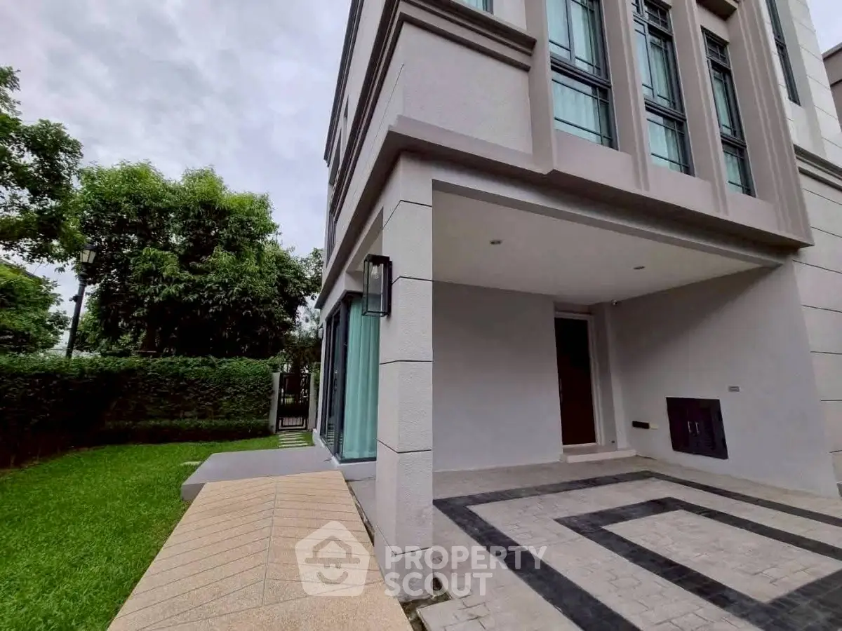 Modern building exterior with lush green garden and stylish entrance