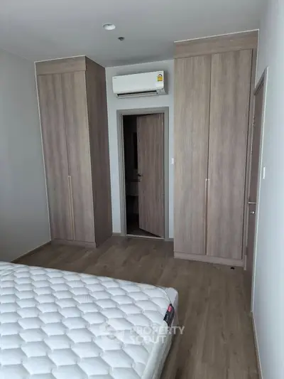 Modern bedroom with built-in wardrobes and air conditioning in a stylish apartment.