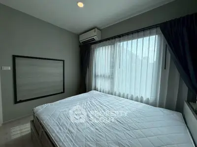 Modern bedroom with large window and air conditioning in a stylish apartment.
