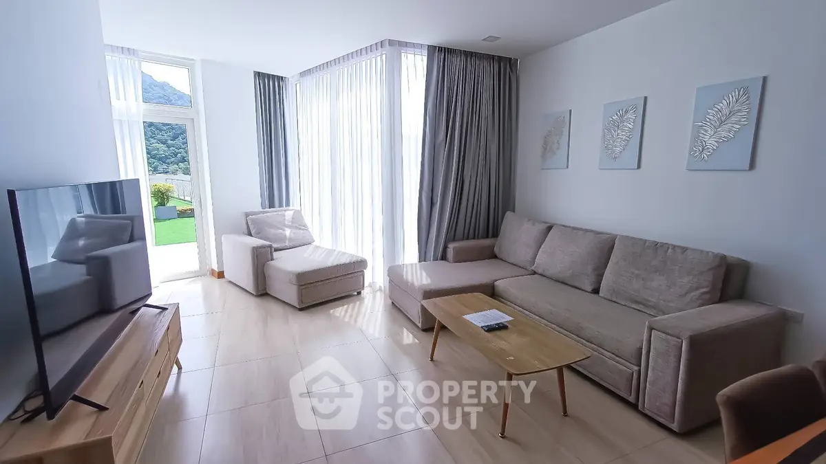Bright and spacious living room with modern furniture and large windows offering scenic views.