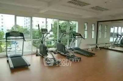 Spacious gym with modern equipment and large windows offering a scenic view.