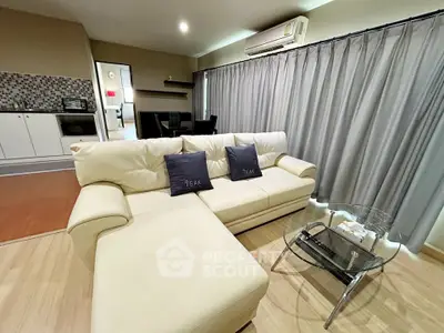 Modern living room with stylish sofa and open kitchen layout in a cozy apartment.