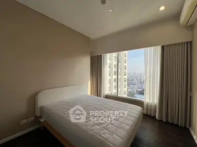 Spacious bedroom with city view and large windows in modern apartment