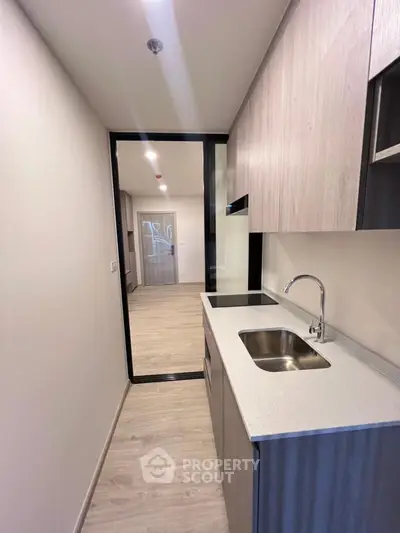 Modern compact kitchen with sleek design and wooden cabinetry