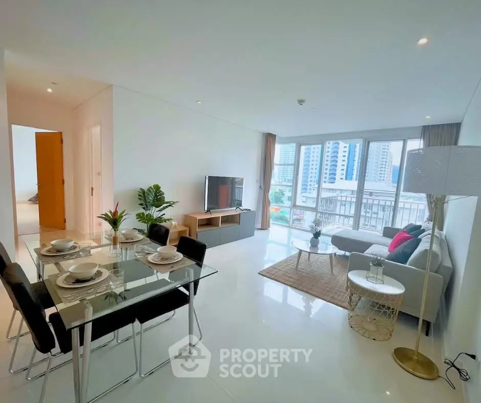 Spacious modern living room with dining area and city view, perfect for urban living.