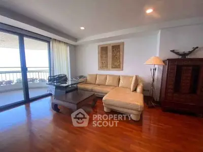 Spacious living room with elegant wooden flooring and large balcony access.