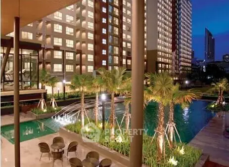 Luxurious apartment complex with stunning pool and lush landscaping at dusk.