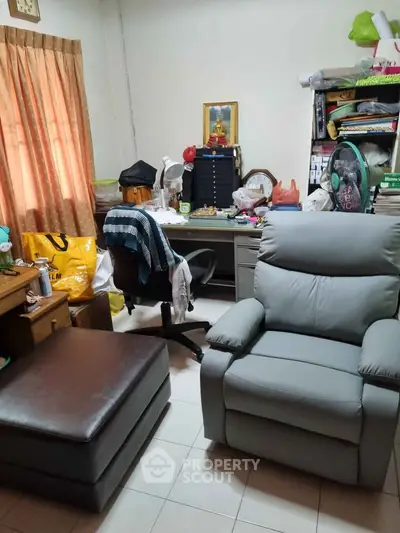 Cozy study room with desk, chair, and recliner, ideal for work-from-home setup.