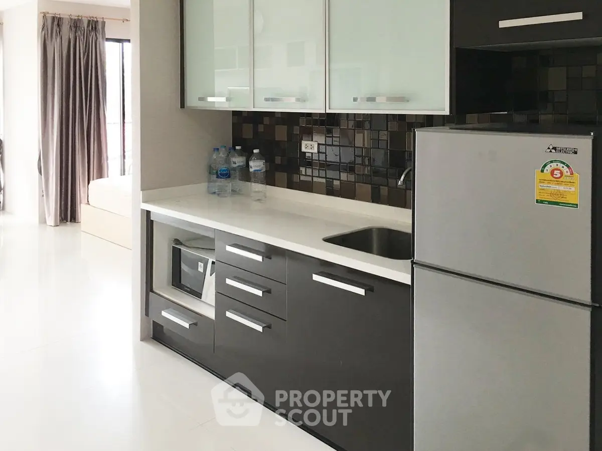 Modern kitchen with sleek cabinetry and stainless steel appliances in a bright apartment.
