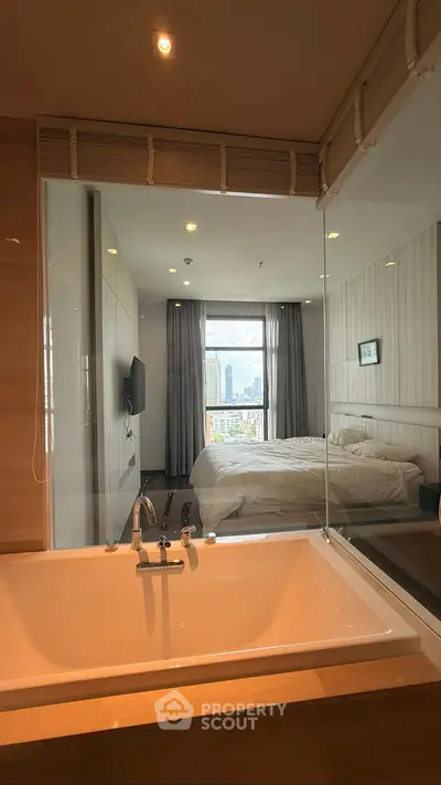 Modern bedroom with bathtub and city view, featuring sleek design and natural light.