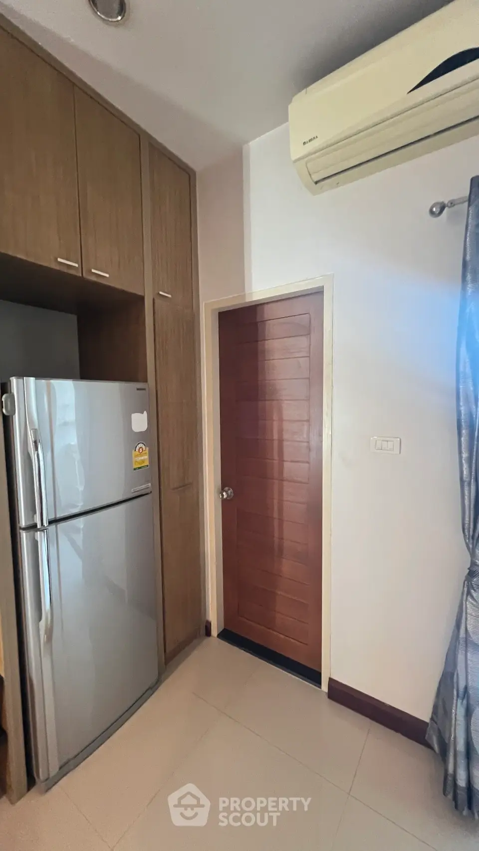 Modern kitchen corner with fridge and air conditioning in stylish apartment.