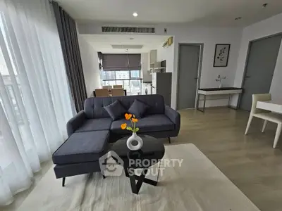Modern living room with stylish furniture and open kitchen layout in a bright apartment.