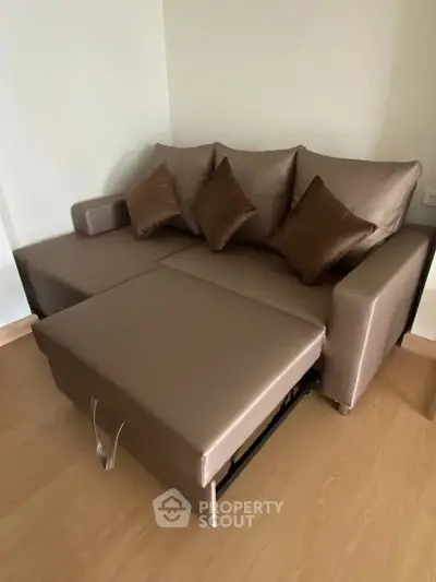 Modern living room with stylish brown sofa bed and wooden flooring