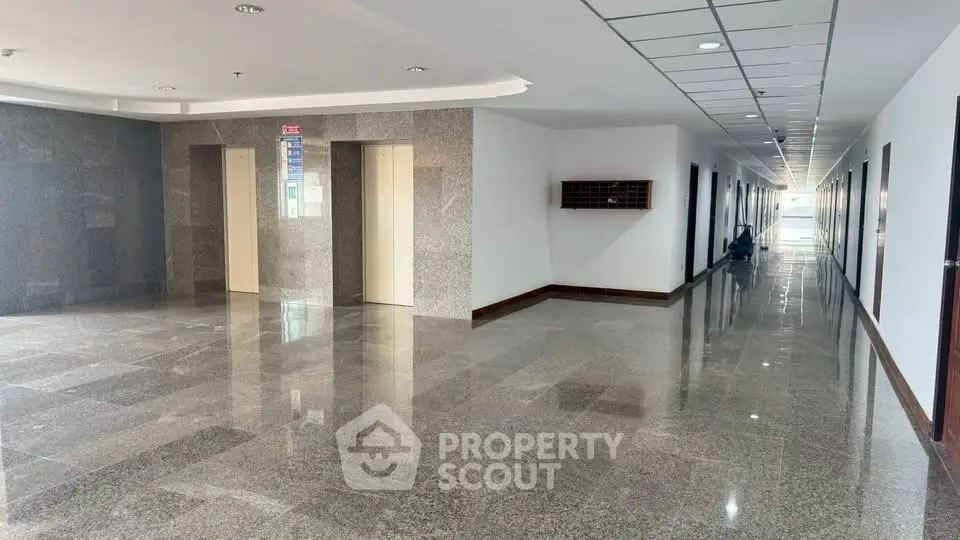 Spacious modern building hallway with elevators and polished flooring