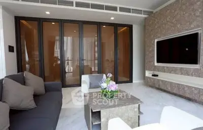 Luxurious modern living room with stylish furniture and large TV, perfect for relaxation.