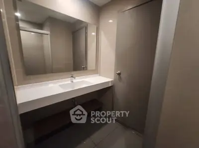 Modern bathroom with sleek design and large mirror in contemporary apartment.
