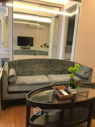 Stylish living room with modern sofa and glass coffee table, perfect for relaxation.