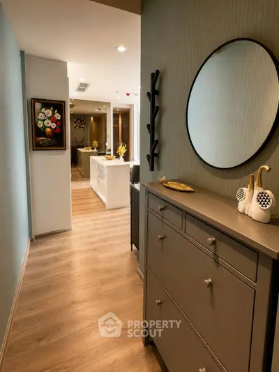 Stylish hallway with modern decor leading to a spacious living area, featuring elegant wooden flooring and contemporary furnishings.