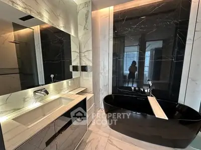 Luxurious modern bathroom with sleek black bathtub and elegant marble finishes.