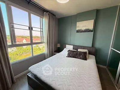 Cozy bedroom with large window and modern decor, offering a serene view.