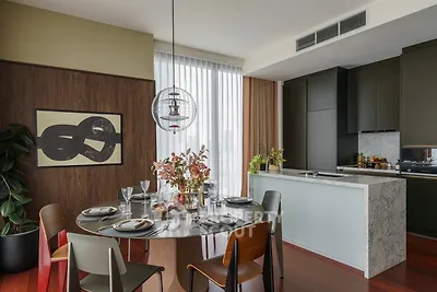 Modern dining area with stylish decor and open kitchen layout in a luxury apartment.