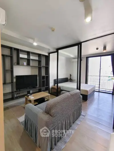 Modern open-layout living room with stylish furniture and balcony view