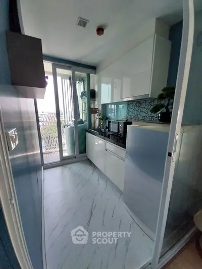 Modern compact kitchen with sleek design and balcony access