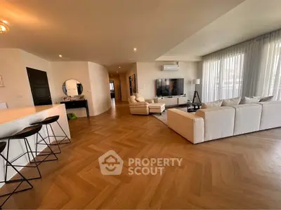 Spacious modern living room with elegant parquet flooring and stylish furniture.