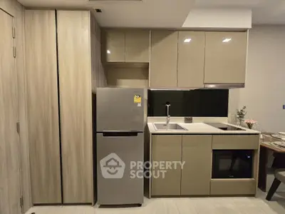 Modern kitchen with sleek cabinetry and built-in appliances in a compact layout.